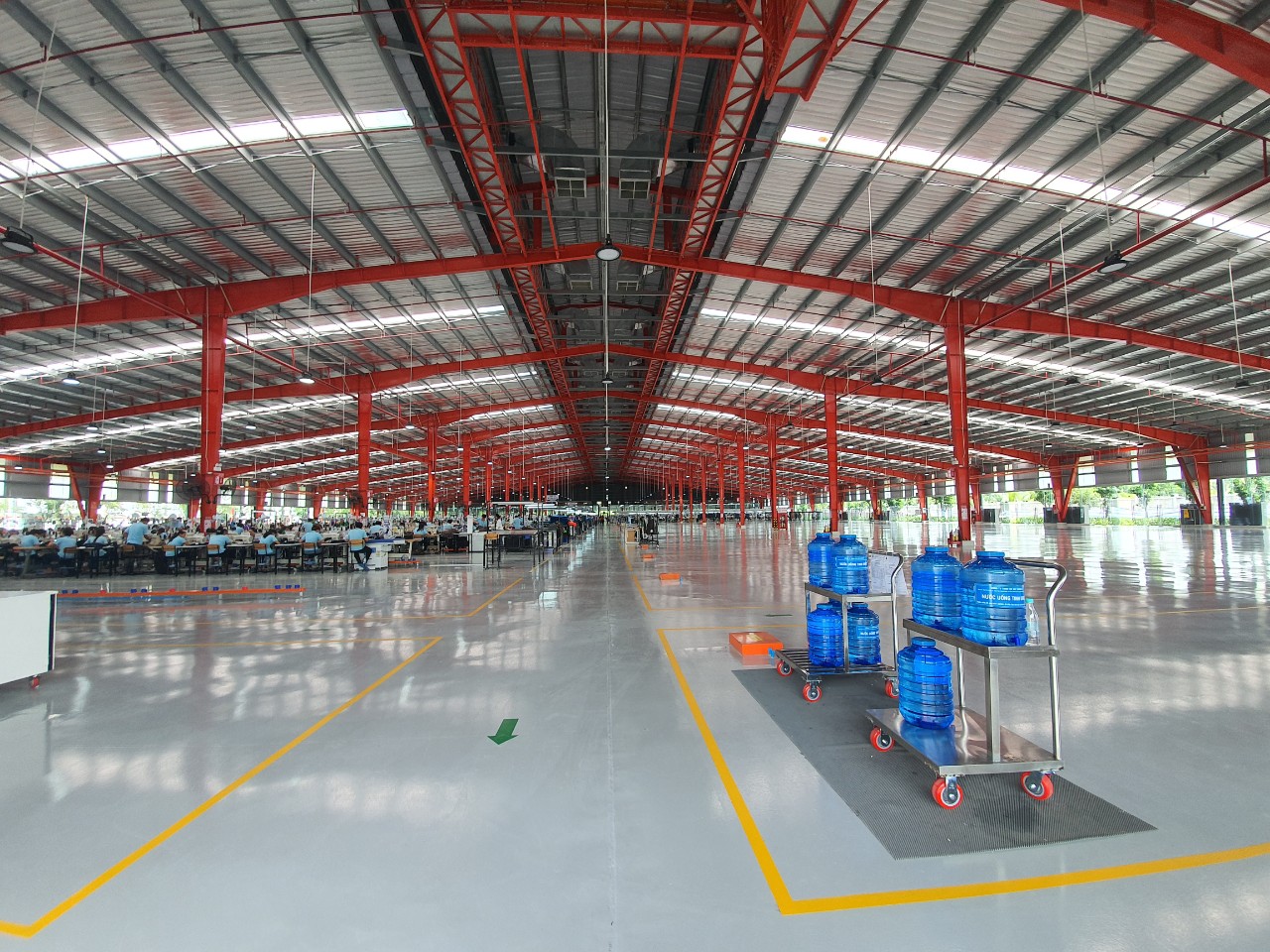 Mặt bằng xưởng Việt Vương 2: lối đi rộng đã kẻ vạch vàng, xe đẩy tay đang đỗ trên tuyến